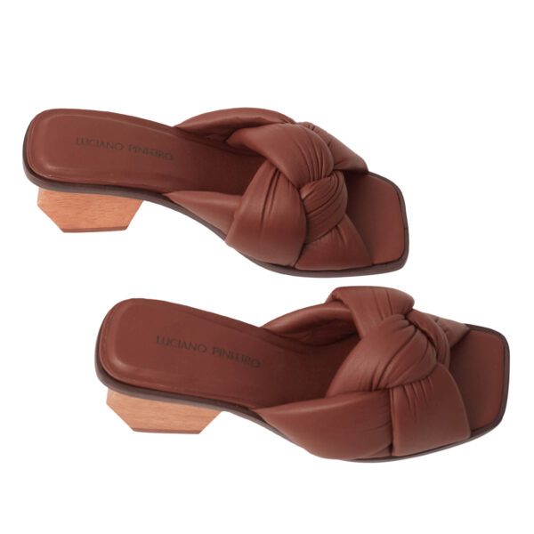 Mule de luxo em couro caramelo, com cabedal de nó robusto e salto geométrico esculpido em madeira maciça.