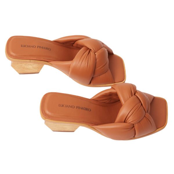Mule de luxo em couro caramelo, com cabedal de nó robusto e salto geométrico esculpido em madeira maciça.